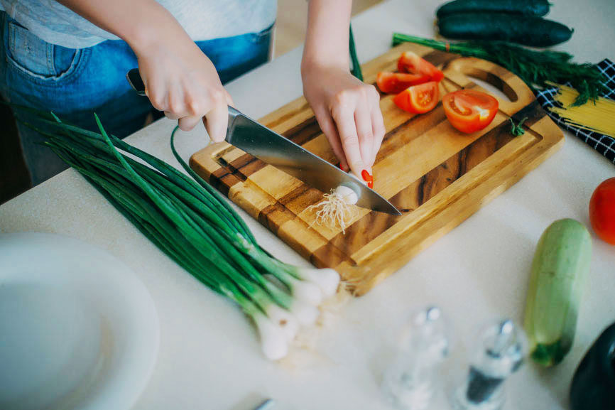 Chopping vegetables on wooden cutting board