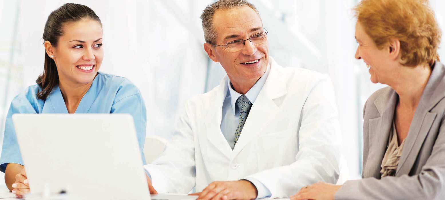 Doctor talking to two people at a table